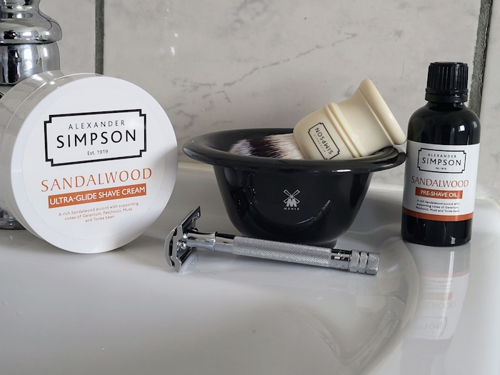 Simpson Sandalwood Pre-Shave Oil with shaving bowl, cream and safety razor on a sink