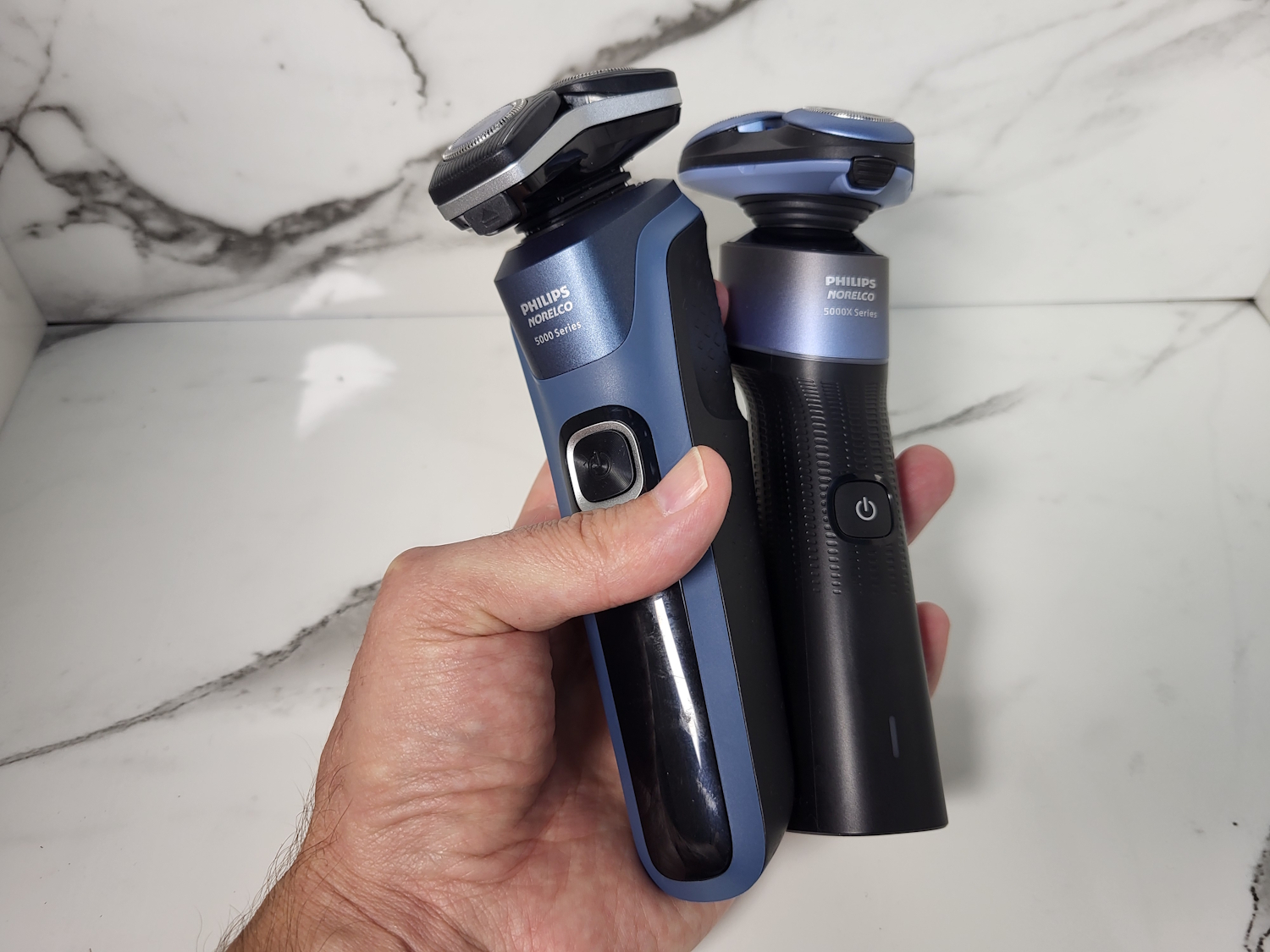 holding a Philips 5000 Series Shaver and Philips 5000x with marble background
