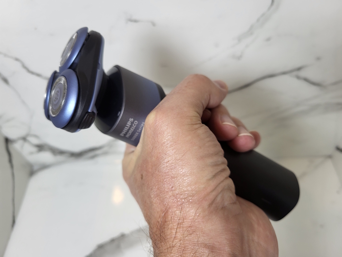 holding the Philips 5000X Shaver to show its ergonomics