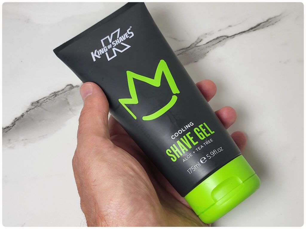 holding a tube of King of Shaves Cooling Shave Gel
