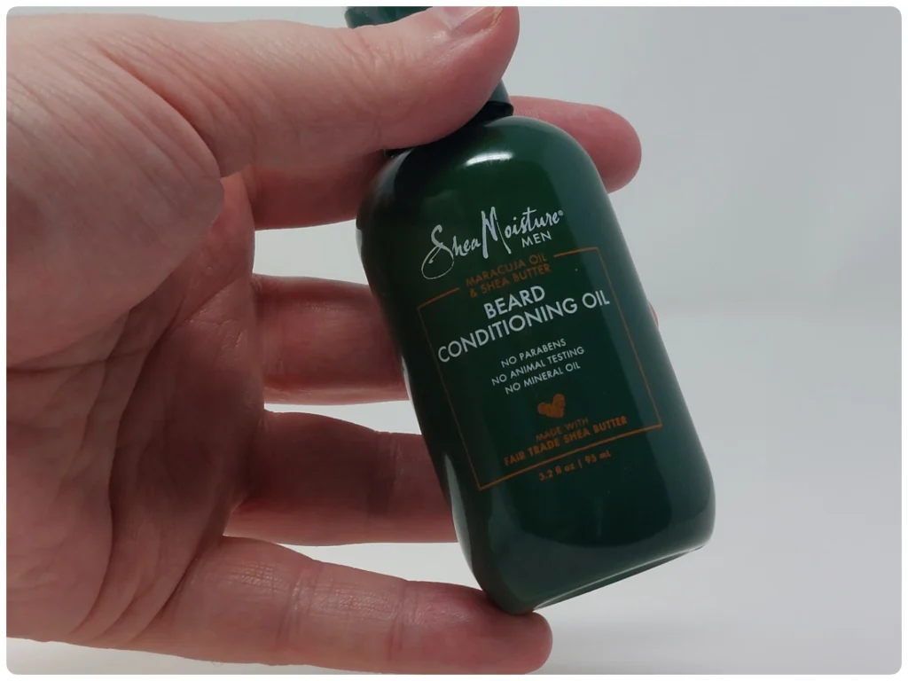 holding SheaMoisture Beard Conditioning Oil bottle