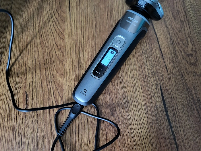 Philips i9000 Prestige charging with cord attached and LED lit up