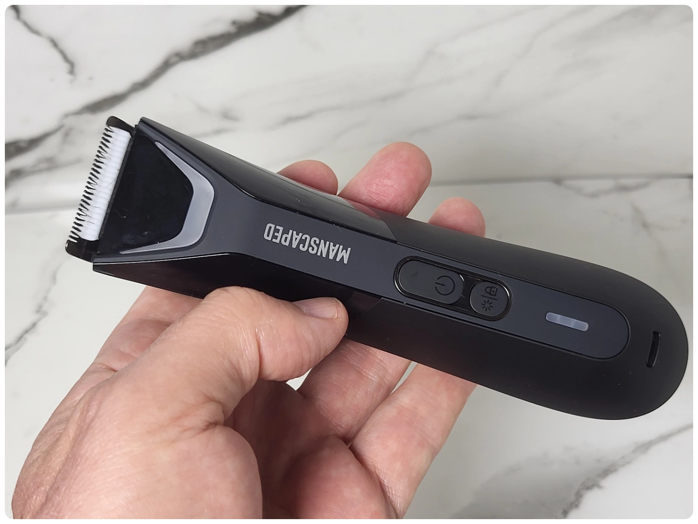 holding the Manscaped Lawn Mower 5.0 Ultra to display its appearance