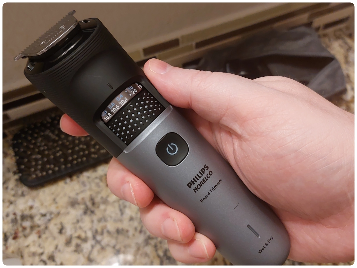 holding Philips Norelco Series 7000 Beard Trimmer to display its appearance