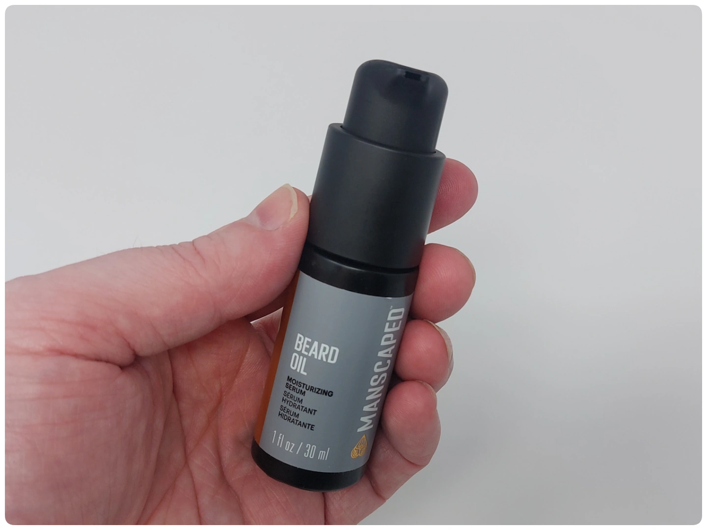 holding a bottle of Manscaped Beard Oil to display how it looks
