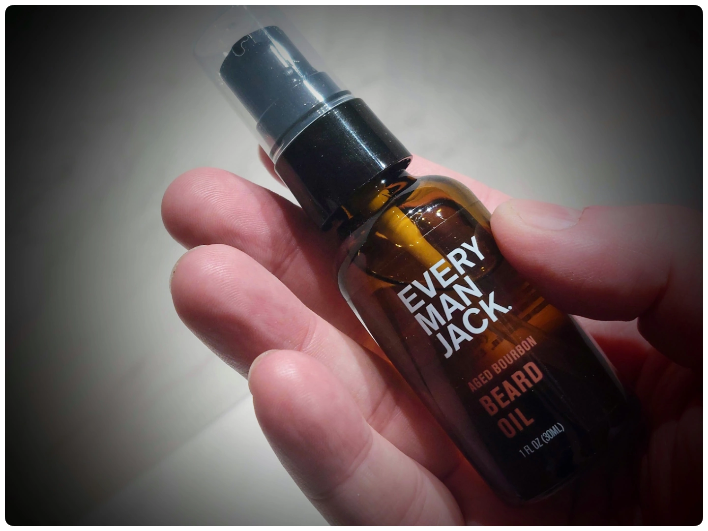 holdng a bottle of Everyman Jack Aged Bourbon Beard Oil