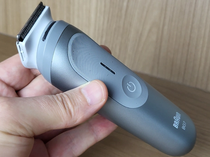 holding the Braun Body Groomer Series 7 between fingers to display its fairly small size