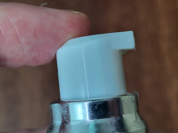 Domepeace Mattifying Moisturizer pump top with finger on the top to press it