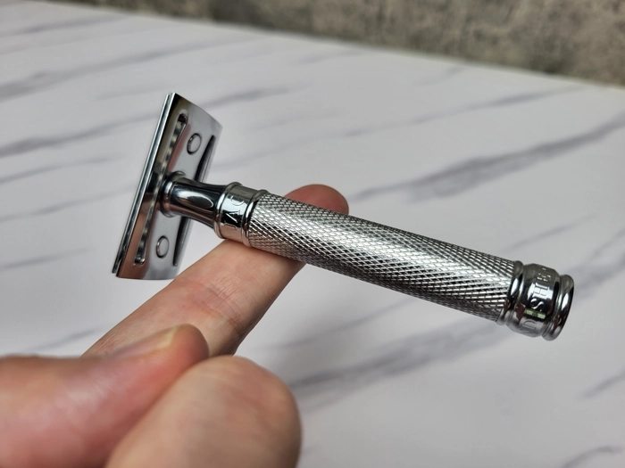 balancing Muhle R89 razor on one finger to display how it balances weight